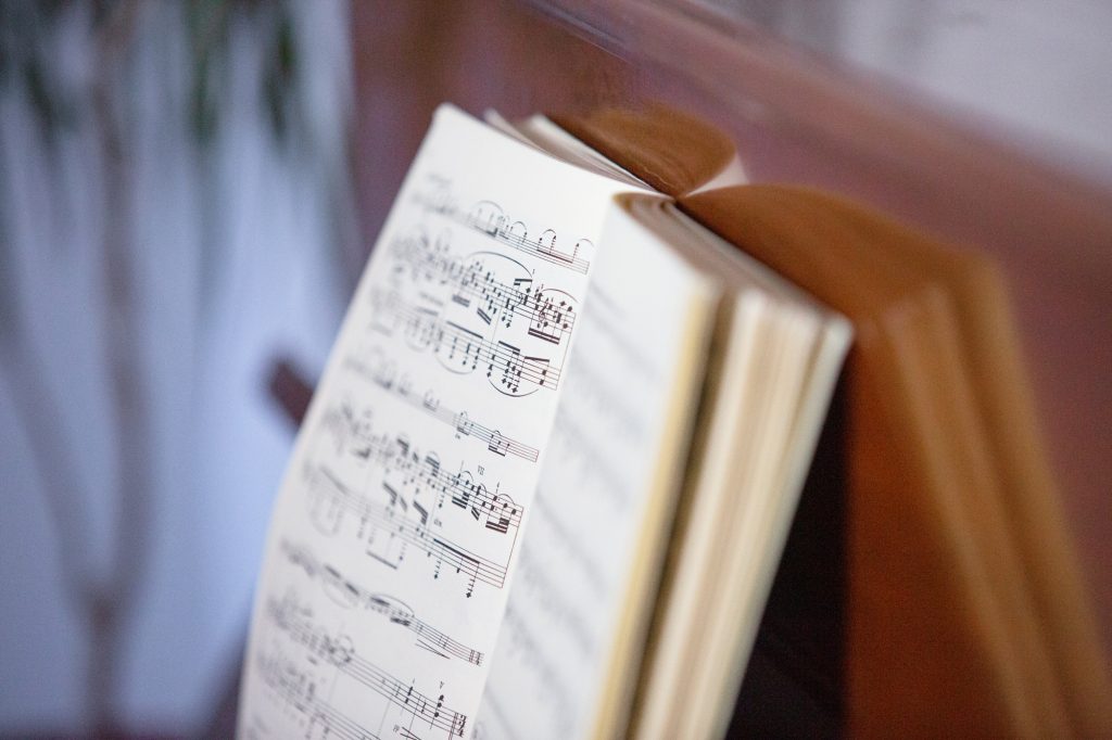 Avoin nuottivihko pianoa vasten.