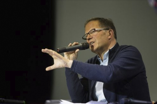 François Combeau pitää puhetta mikrofoni kädessä.